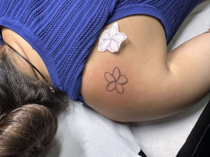 Frangipani flower outline on the shoulder, with its stencil