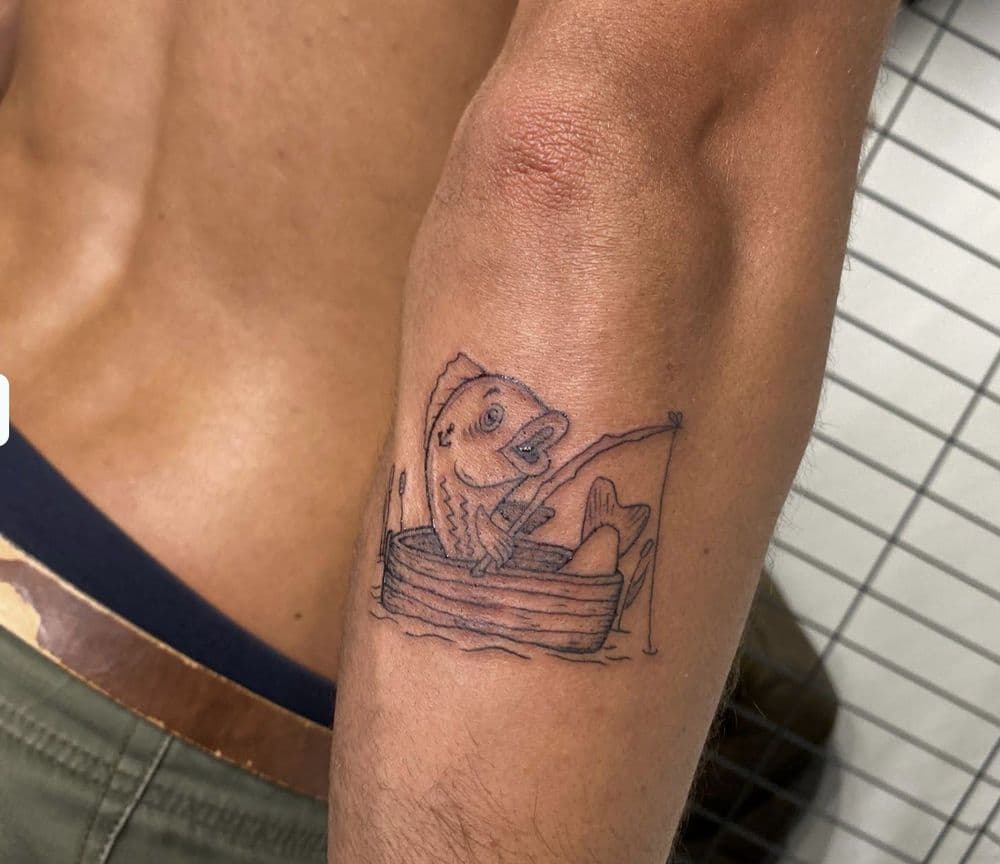 A fish fishing from a boat, tattooed on the forearm