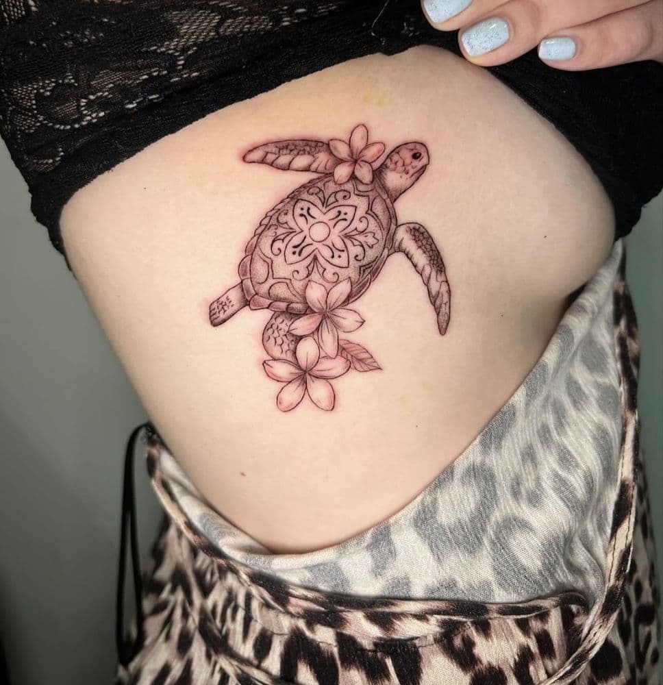 Sea turtle with flowers tattooed on the ribs